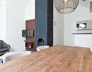 Stijlvolle eetkamer in vakantiehuis Vaassen, Veluwe, met houten tafel.