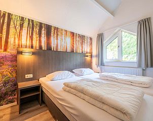 Sfeervolle slaapkamer in vrijstaande woning Vaassen, Veluwe, met bosbehang.