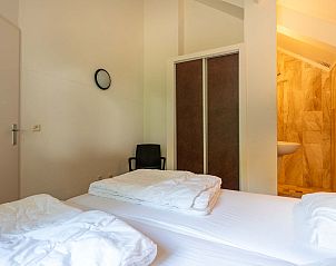 Ruime slaapkamer in vakantiehuis Vaassen, Veluwe, met moderne badkamer.