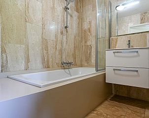 Moderne badkamer in vakantiehuis Vaassen, Veluwe, met ligbad en wastafel.