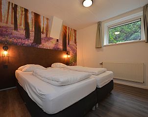Slaapkamer met tweepersoonsbed in vakantiehuis in Vaassen, Gelderland.