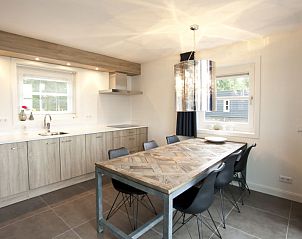 Ruime eetkamer in Vakantiehuis Villa Waterfront 6, Hulshorst, Veluwe, Gelderland met houten tafel en moderne stoelen.