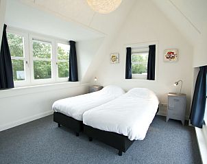 Comfortabele slaapkamer in Vakantiehuis Villa Waterfront 6, Hulshorst, Veluwe, Gelderland met twee bedden en veel licht.