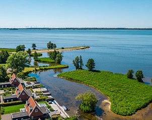 Uitzicht op het meer bij Vakantiehuis Villa Waterfront 6, Hulshorst, Veluwe, Gelderland met groene oevers.