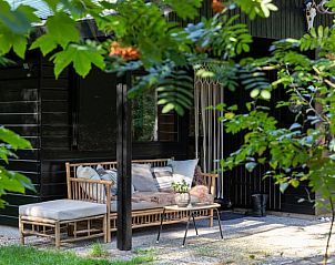 Knusse zithoek op veranda van vakantiehuis in Hulshorst, Veluwe, Gelderland.