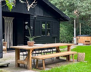 Houten eettafel op terras bij vakantiehuis in Hulshorst, Veluwe, Gelderland.