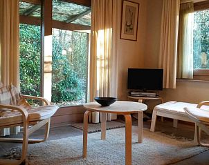 Lichte zithoek in Vakantiehuisje in Hulshorst met uitzicht op de Veluwse natuur, Gelderland.