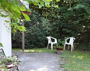 Schaduwrijke tuin van Vakantiehuisje in Hulshorst met zitjes, Veluwe, Gelderland.