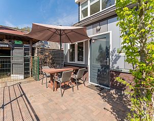 Ruim terras van Pimpelmees vakantiewoning in Hulshorst, Veluwe met zitgelegenheid en parasol.