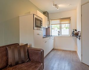 Keuken en zithoek in Pimpelmees vakantiehuis in Hulshorst, Veluwe met moderne inrichting.