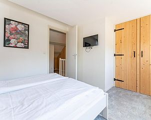 Slaapkamer in Pimpelmees vakantiewoning in Hulshorst, Veluwe met TV en houten kast.