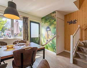 Eetkamer in vakantiehuis Koolmees, Hulshorst, Veluwe met moderne inrichting en uitzicht op tuin.