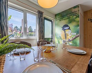 Eettafel in vakantiehuis Koolmees, Hulshorst, Veluwe met uitzicht op de tuin en moderne inrichting.