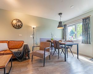 Eetkamer in vakantiehuis Koolmees, Hulshorst, Veluwe met moderne inrichting en uitzicht op de tuin.