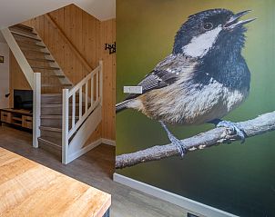 Unieke muurdecoratie in vakantiehuis Zwarte Mees, Hulshorst. Grote afbeelding van een mees op een tak bij de trap.