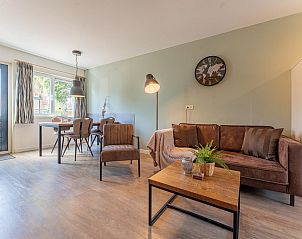 Gezellige zithoek in vakantiehuis Zwarte Mees, Hulshorst. Comfortabele bank en stoelen met uitzicht op de tuin.