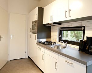 Strakke keuken in Vakantiehuis Cube La Mer, Hulshorst, Veluwe, met veel opbergruimte.