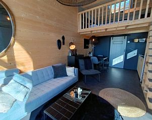 Gezellige woonkamer met loft in Vakantiehuis Tiny House 2 Hulshorst Veluwe, ideaal voor ontspanning.