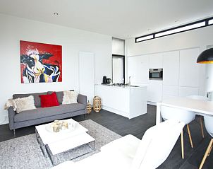 Open keuken en zithoek in Vakantiehuis Cube Exclusif Waterfront 4, Hulshorst, Veluwe, met moderne kunst aan de muur.