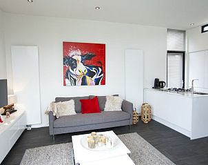 Gezellige zithoek in Vakantiehuis Cube Exclusif Waterfront 4, Hulshorst, Veluwe, met kleurrijke decoraties.