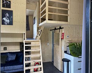 Houten loft in Vakantiehuis Tiny House 4, Hulshorst, Veluwe, met trap naar slaapgedeelte en open design.