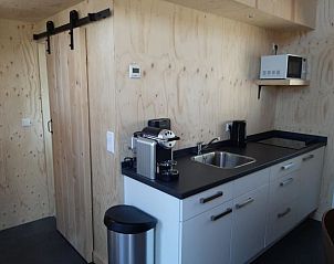 Compacte keuken in Vakantiehuis Tiny House 4, Hulshorst, Veluwe, met alle moderne gemakken en houten afwerking.