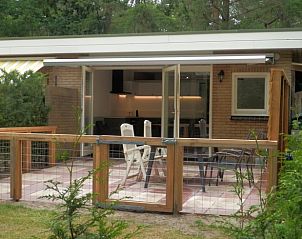 Gemtliches Wohnzimmer des Ferienhauses in Otterlo, Veluwe, mit komfortabler Sitzecke und Blick auf die waldreiche Umgebung von Gelderland.