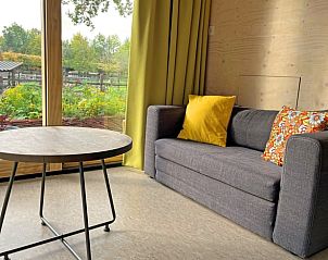 Gemtlicher Innenbereich mit Sofa und Gartenblick im Ferienhaus in Otterlo.