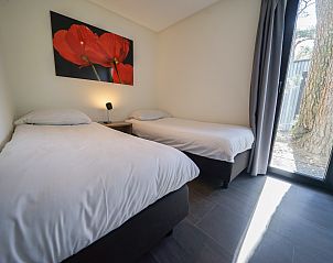 Tweede slaapkamer in Chalet in Otterlo, Veluwe, met twee eenpersoonsbedden en veel natuurlijk licht.