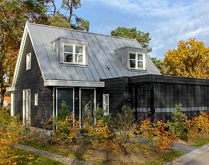 Villa Wellness 4, een charmant vakantiehuis in Otterlo, Veluwe, omringd door kleurrijke herfstbladeren en serene natuur.