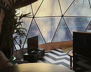 Binnenruimte van Huisje in Otterlo, een vakantiehuis in Otterlo, Veluwe, met uniek uitzicht door een glazen koepel in de natuur van Gelderland.