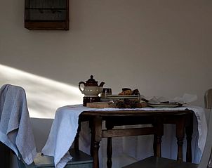 Gemtliche Essecke im Ferienhaus in Otterlo, Veluwe, Gelderland, mit rustikalem Tisch und warmer Atmosphre fr einen entspannten Aufenthalt.