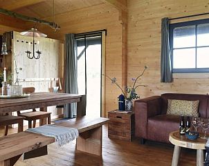 Gezellige binnenruimte van Vakantiehuisje in Oosterwolde Gelderland met houten interieur en comfortabele zithoek.