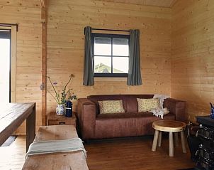 Comfortabele woonkamer met bank in Vakantiehuisje in Oosterwolde Gelderland, perfect voor ontspanning na een dag in de natuur.