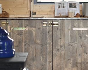 Landelijke keuken in Huisje in Oosterwolde Gelderland met houten kasten en moderne accenten.