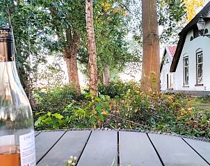 Buitenruimte van Vakantiehuis in Epe, Veluwe, Gelderland met rustieke tafel en omliggend groen.