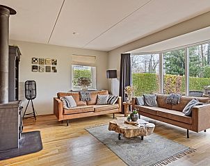 Cozy living room of Holiday Home in Epe, Veluwe, Gelderland with comfortable sofas and views of the green garden.