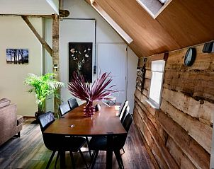 Attractive dining area in Holiday cottage in Epe, Veluwe, Gelderland with wooden walls and skylights.