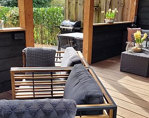 Enjoy the cozy veranda of Holiday Home in Epe in Veluwe, Gelderland, with comfortable seating areas and green surroundings.