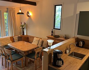 Gezellige binnenruimte van vakantiehuis Boshuis Wissel in Epe, Veluwe, met houten interieur en uitzicht op de groene natuur.