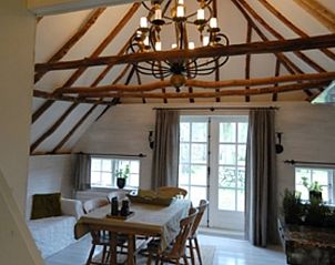 Gemtlicher Innenbereich des Ferienhauses in Vierhouten, Veluwe, mit stimmungsvollen Holzbalken und lndlicher Einrichtung in Gelderland.