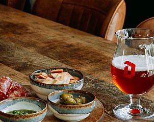 Delicious snacks and a glass of beer at Holiday Home in Nunspeet, Veluwe, perfect for a relaxing evening.