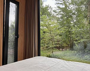Relax in the Holiday Home in Nunspeet with a serene bedroom view of the green Veluwe, Gelderland.
