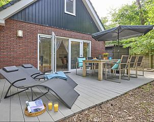 Terrace of De Linde vacation home in Nunspeet, Veluwe, with comfortable deck chairs and dining table.