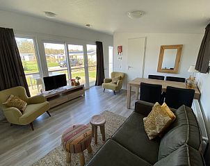 Gemtliches Wohnzimmer in einem freistehenden Haus in Nunspeet, Veluwe, Gelderland, mit moderner Einrichtung und Blick auf die grne Umgebung.