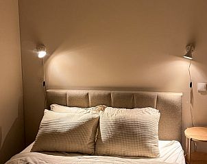 Gemtliches Schlafzimmer im Ferienhaus in Nunspeet, Veluwe, mit stimmungsvoller Beleuchtung und bequemem Bett fr einen entspannten Aufenthalt.