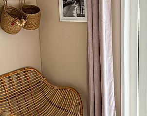 Stilvolle Ecke mit Rattanstuhl im Ferienhaus in Nunspeet, Veluwe, Gelderland, perfekt fr Entspannung und Naturerlebnis.