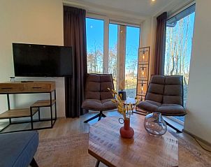 Comfortabele zithoek in Vakantiehuis Villa Wellness 8, EuroParcs Veluwemeer, Nunspeet, met uitzicht op de natuur van de Veluwe.