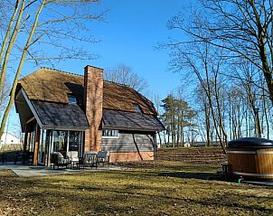 Achteraanzicht van Vakantiehuis Villa Wellness 8, EuroParcs Veluwemeer, Nunspeet, met hot tub en terras op de Veluwe.