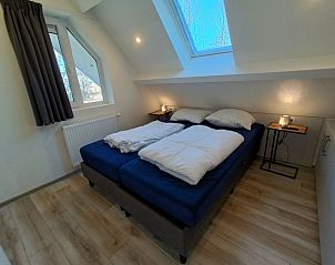 Knusse slaapkamer onder het dak in Vakantiehuis Villa Wellness 8, EuroParcs Veluwemeer, Nunspeet, met natuurlijk licht op de Veluwe.